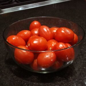 a bowl of tomatoes sitting on a counter top